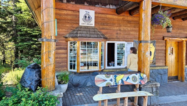 The new coffee window for Fernie's Coffee in Government Camp. It is in the wall at Vallian's Sports with a bench and plants in front.